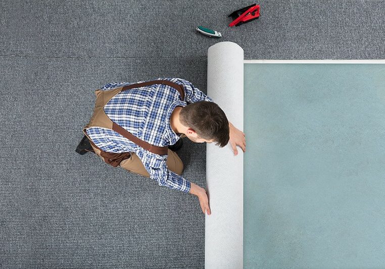 Carpet Installer rolling out new carpet | The L&L Company